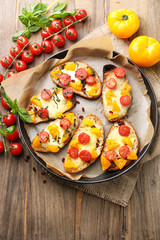 Tasty bruschetta with tomatoes on pan, on old wooden table