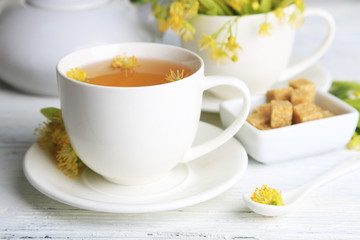 Tasty herbal tea with linden flowers on wooden table