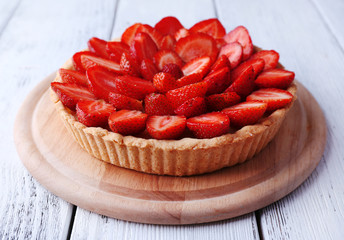 Strawberry tart on color wooden background