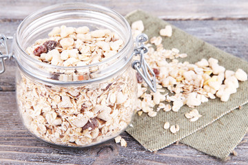 Homemade granola in glass jar, on color wooden background