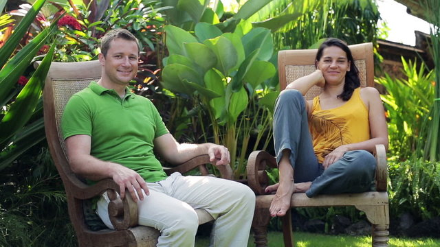 Happy couple sitting in the garden and smiling to the camera