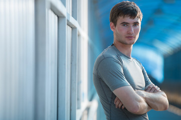 Athlete posing outdoors in city. Standing with hands folded