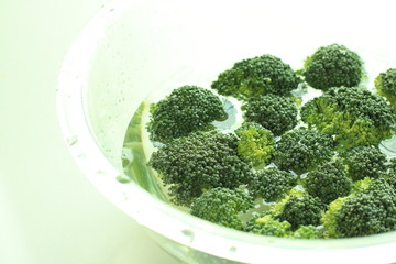 chopped broccoli in water for food preparation image
