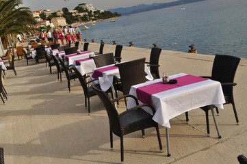 Tables and chairs of restaurant in port of Podgora, Croatia