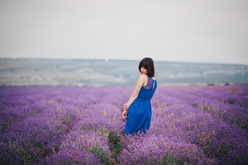 Young woman wearing blue dress standing in a lavender field