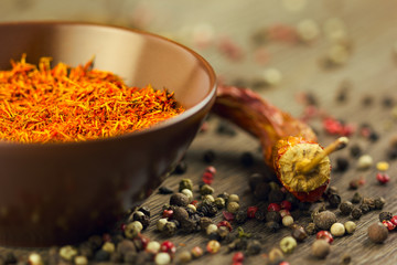 Saffron in brown bowl with chili and pepper