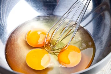 Foto auf Acrylglas whisking eggs in metal bowl © marylooo