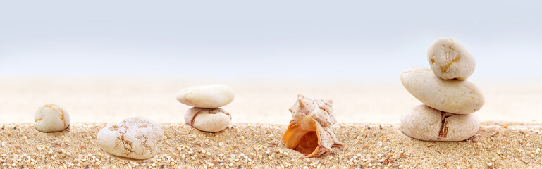 Panorama of zen stones on a sandy beach.