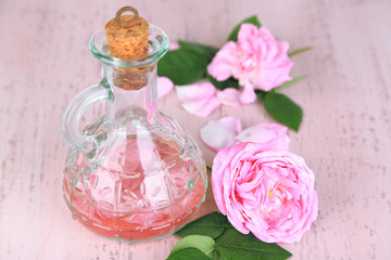 Obraz na płótnie Canvas Rose oil in bottle on color wooden background