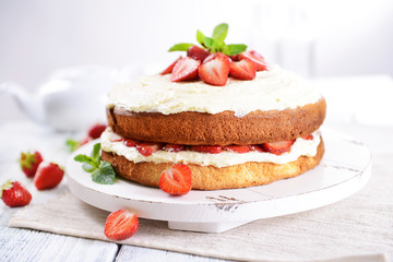 Delicious biscuit cake with strawberries on table close-up