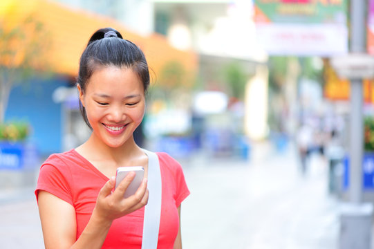 young asian woman use her cellphone on shopping street