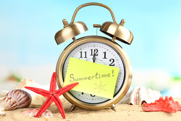 Summertime. Old clock on sand