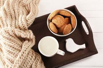 Milk and cookies on tray on table
