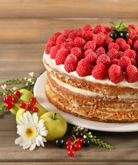 Tasty cake with fresh berries on wooden table
