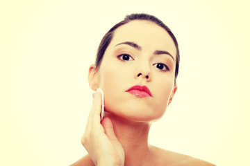 Young beautiful caucasian woman using a cotton pad