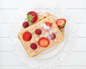 Delicious waffle with fresh berries for breakfast on wooden whit