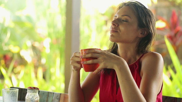 Pretty woman drinking tea, relaxing by table in garden