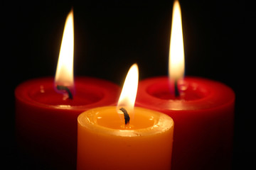 Drei Kerzen brennen in der Dunkelheit
