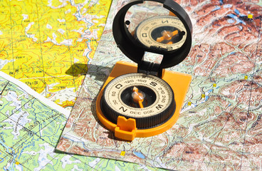 Compass lies on a topographic map.