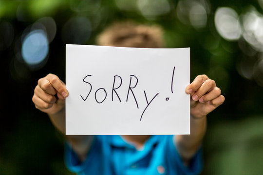 Boy with Sorry sign
