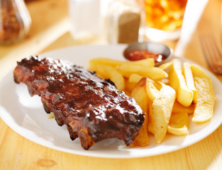 plate with barbecue ribs and french fries
