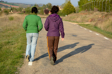 dos mujeres caminando por una carretera