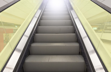 Obraz premium Empty escalator or moving stair. Also called stairway or staircase. Modern architecture design with step, glass for lift people up floor building i.e. shopping mall, airport, metro and subway station.