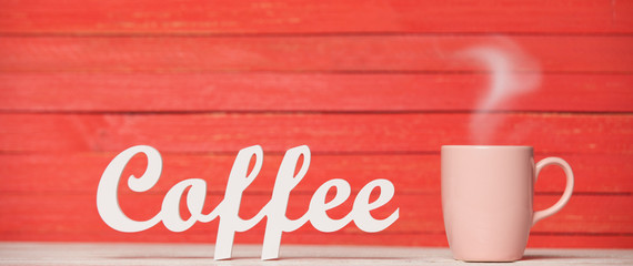 Abstract wooden word Coffee with cup on red wooden background.