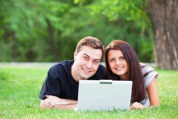Teen couple with gift in the park.