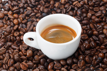 Cup of hot coffee on coffee bean background