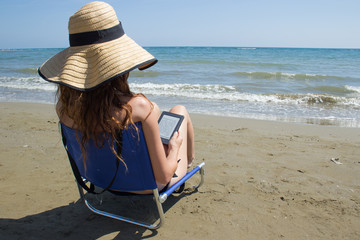 girl on the beach with ebook reader