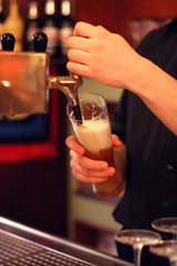 Kellner zapft ein Bier