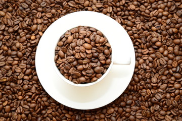 cup with coffee grains on a saucer, view from the top