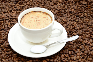 cup of coffee with cinnamon and a spoon of sugar