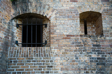 Iron bars, gun slot in brick wall