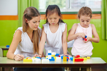 Children playing with building blocks in kindergarten
