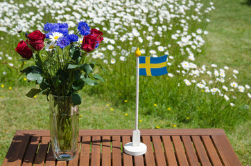Table with summer flowers and a swedish flag