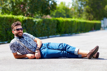 cheerful young adult man lying on the road