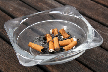 ashtray and cigarettes on wooden background