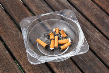 ashtray and cigarettes on wooden table