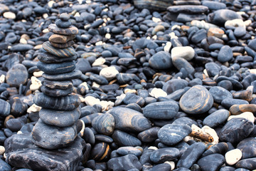 Colorful pebbles touching wave at beautiful rock island, called