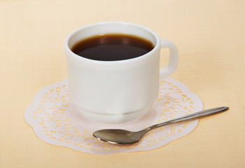 White cup of coffee with white napkin