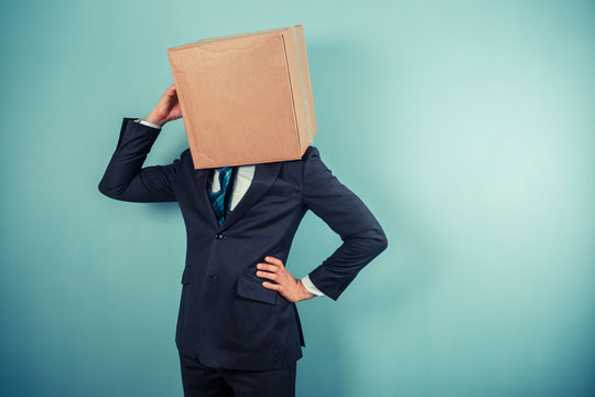 Businessman with a box on his head is cofused