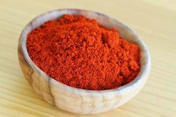 Chili powder in wooden bowl, close up