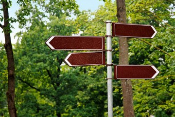 blank way direction signs on green tree background