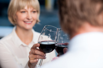 Blur images of couple raises a glass of red wine