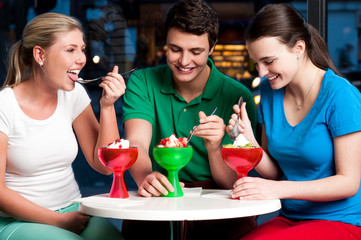 Cheerful friends enjoying tempting dessert