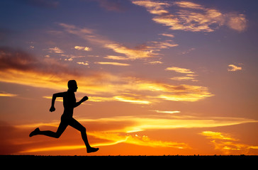 Silhouette of running man on sunset fiery background