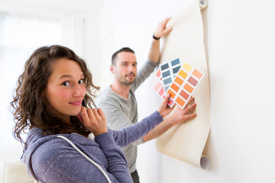 Young couple choosing colors of their wallpaper