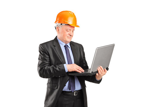 Mature construction worker working on a laptop